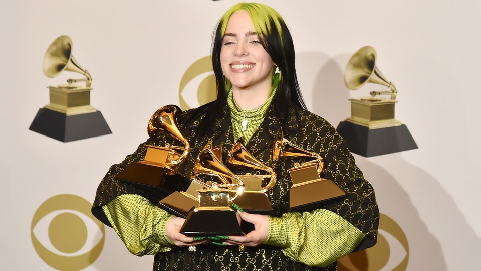 Billie Eilish poses with her Grammys.