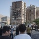 People gather at the scene of a residential complex struck by Israel in Tehran.