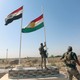 An Iraqi soldier takes down a Kurdish flag in Kirkuk