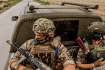 A photo of two Ukrainian soldiers riding in the back of a vehicle