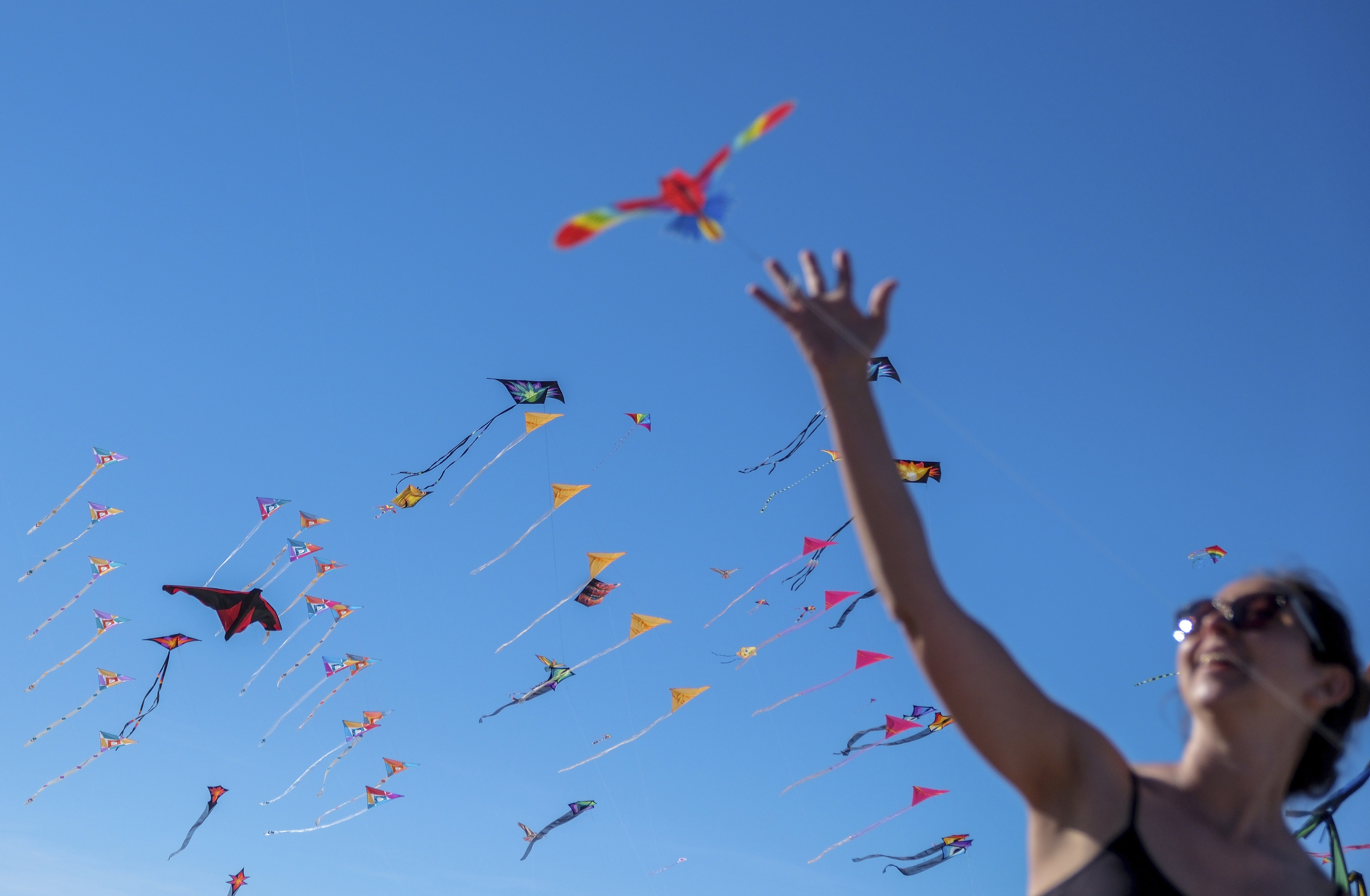 People fly colorful kites during a kite festival.