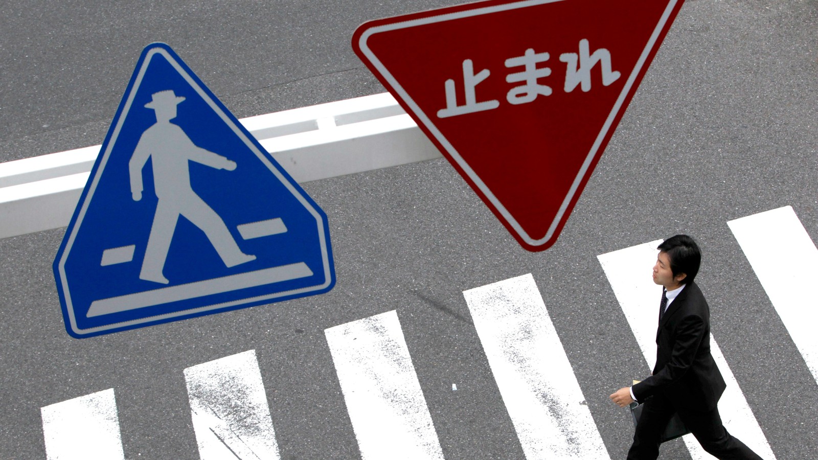 Pedestrian crossing road traffic sign showing a person on a zebra