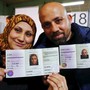 A Syrian couple presents their newly issued German registration documents.