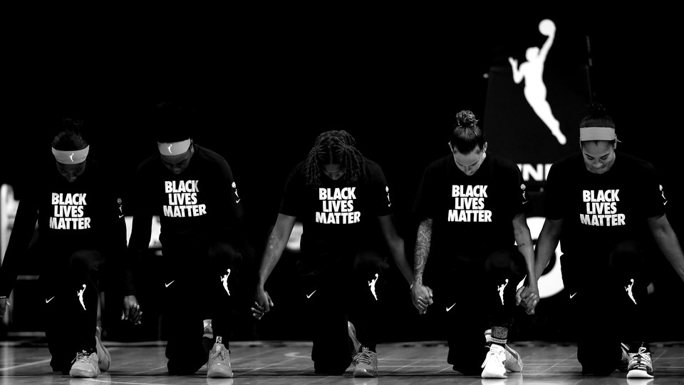 The Atlanta Dream kneeling, wearing Black Lives Matter T-shirts