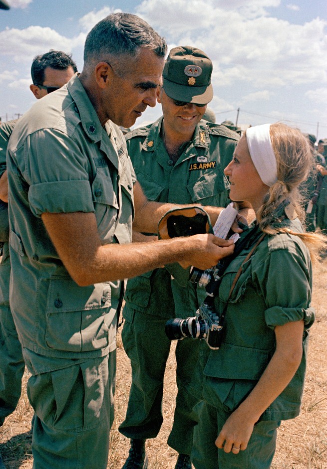 French photojournalist Catherine Leroy receives a pin from Col. Bob Siegholz, 