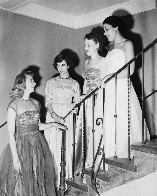 A black and white photo of four sorority sisters on a staircase