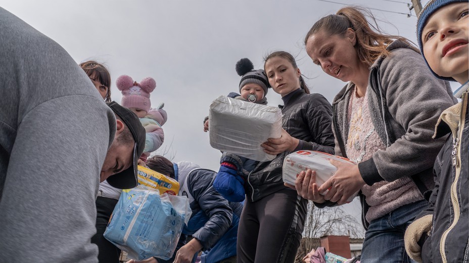 Local aid workers distribute food, baby products, and hygiene items at a Ukrainian village