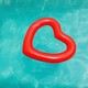 A red heart-shaped floaty in a blue pool