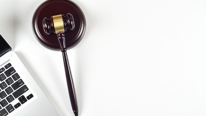 A gavel rests next to a laptop keyboard.