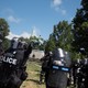 Riot police stand in formation in Charlottesville with a statue of Robert E. Lee behind them.