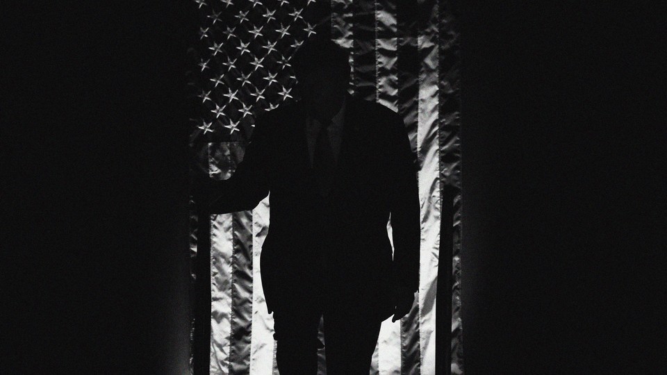 A black-and-white image of Donald Trump silhouetted in front of a draped American flag