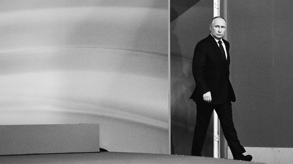 Black-and-white photo of Vladimir Putin in a black suit walking into a room