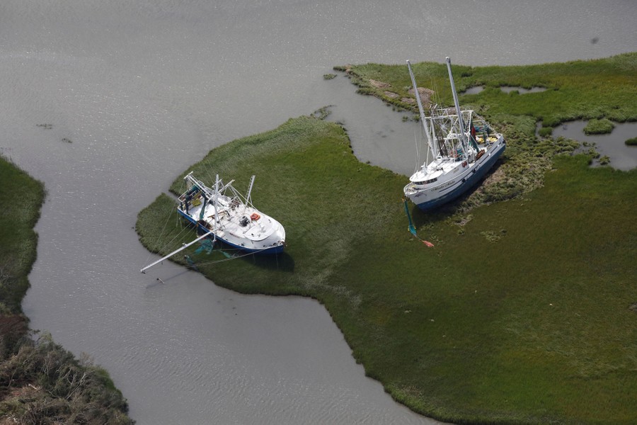 An aerial view shows damaged boats sitting stranded out of the water.