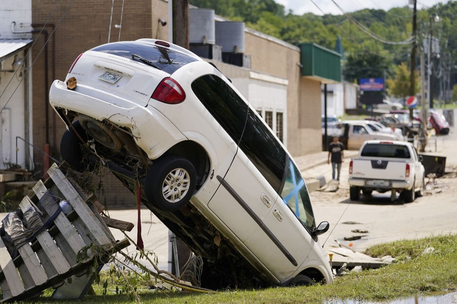 A damaged car was left with its tail in the air after being pushed against the wires of a utility pole.