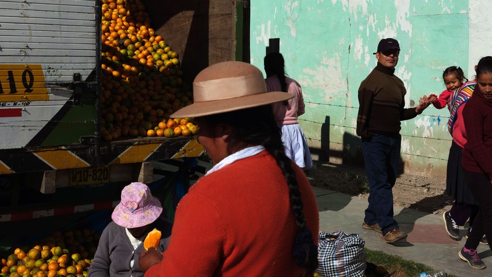 PERU. Chupaca. September 2017. Selling oranges at the weekly animal market.
