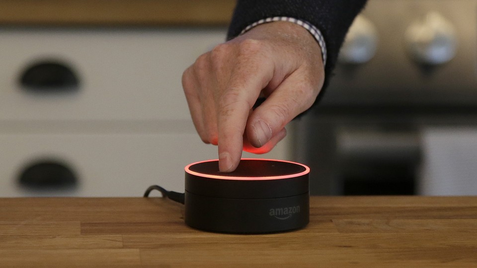 A man mutes an Amazon Echo Dot
