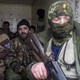 Pro-Russian rebels sit inside a truck, holding guns.