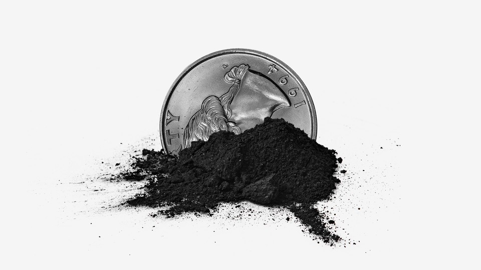 A quarter in a small pile of coal ash