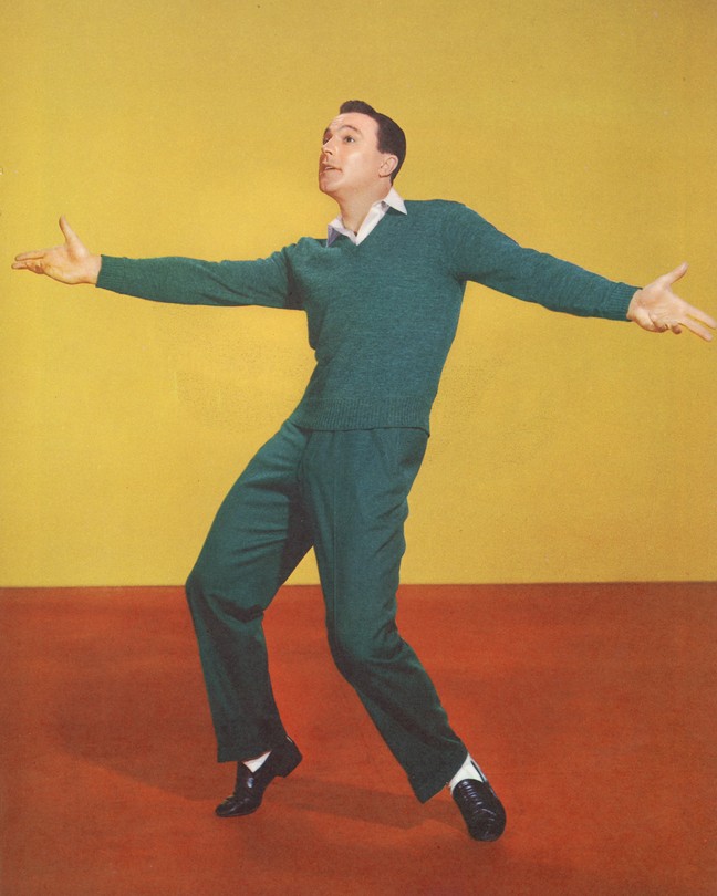 A color photograph of Gene Kelly dancing against a yellow backdrop