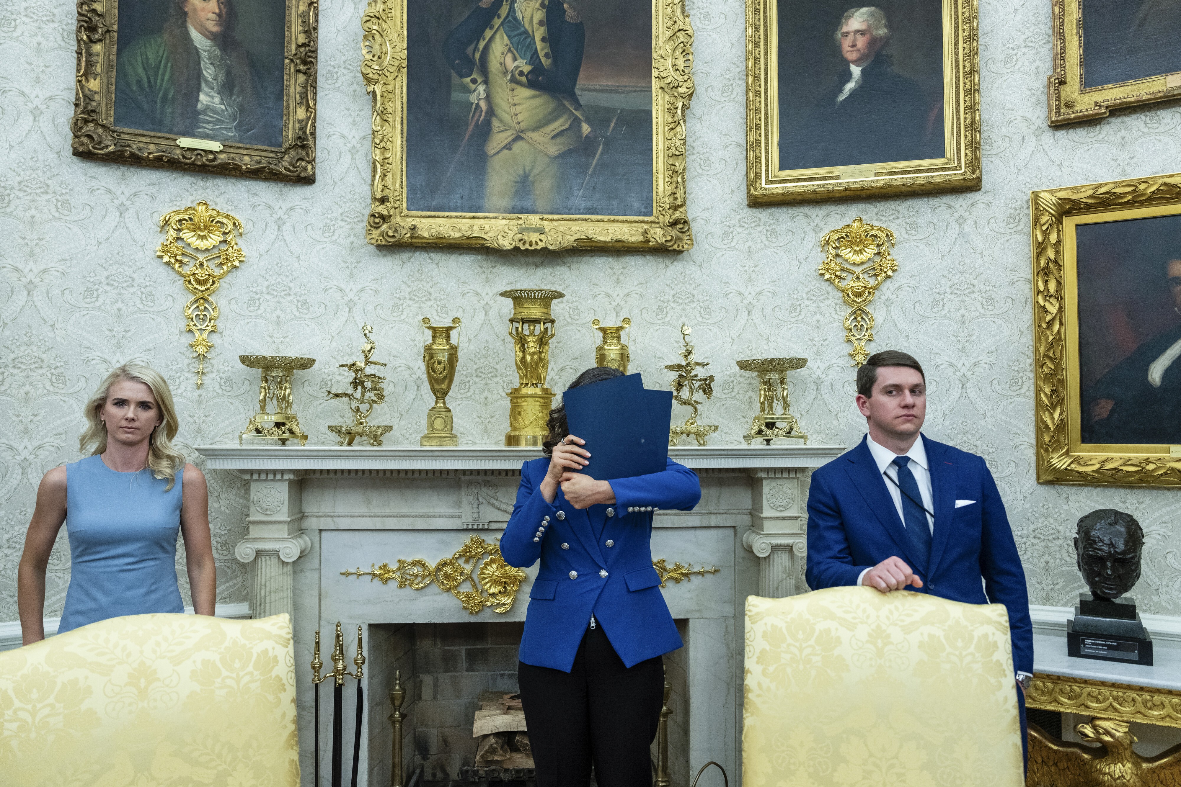 Уитмер закрывает лицо, пока президент Трамп отвечает на вопросы репортеров в Овальном кабинете в апреле прошлого года.