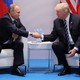 President Trump (right) and President Putin (left) sit on chairs and shake hands while answering questions during a bilateral meeting of the G20 Summit.