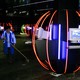 A person cleans up in a room full of computers and neon lights.