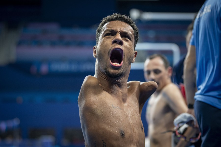 A Paralympic swimmer shouts in celebration after winning a race.