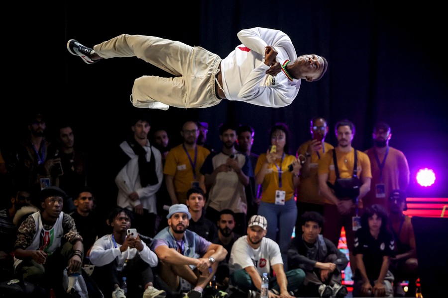 A breakdancer is sideways, in mid-air, during a performance.