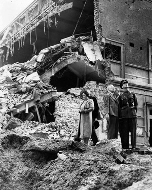 caption: King George VI and Queen Elizabeth (later the Queen Mother) inspect the damage to a cinema building in Baker Street after it was destroyed by Nazi bombing in an air raid over the capital. London, England, 1940