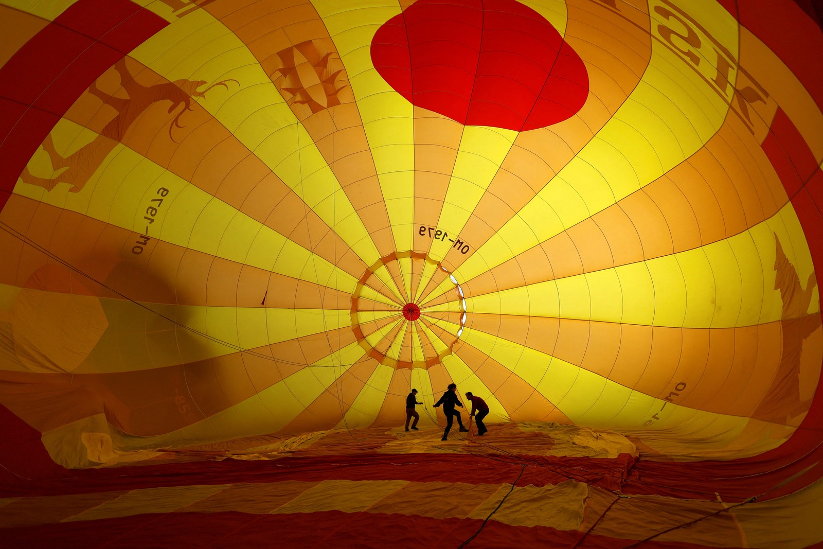 The interior of a large, hot air balloon, with several people walking inside.