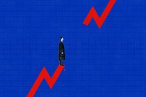 Man in graduation cap standing on trend line