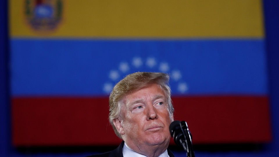 Donald Trump speaks in front of a Venezuelan flag.