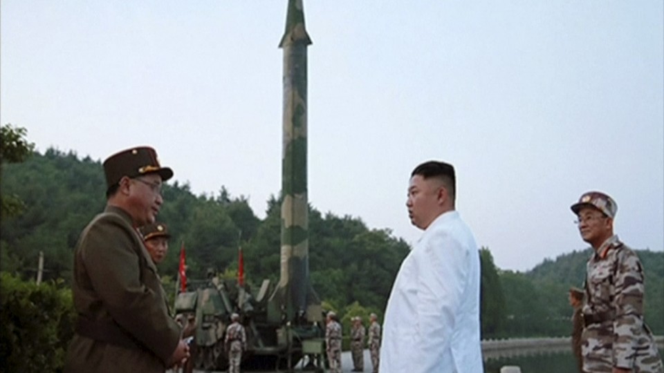 Kim Jong Un and a missile launcher in North Korea