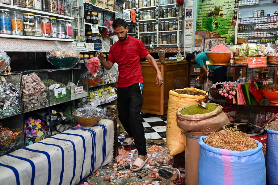 A person walks carefully over broken goods on a shop floor.
