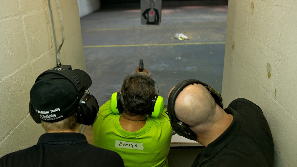 A person shoots a gun at a target. 
