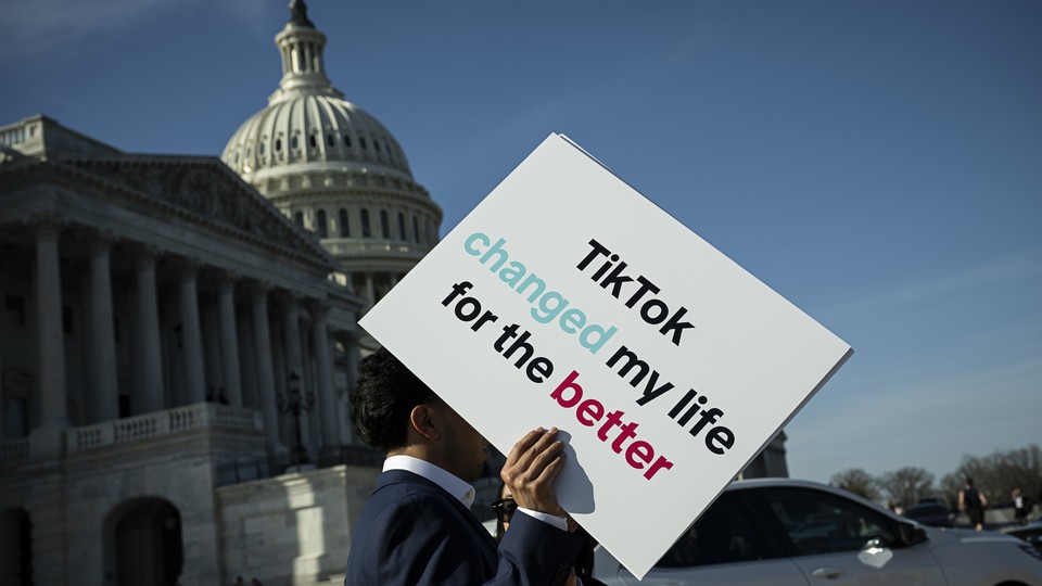 A person holds a sign in front of the Capitol that reads, "TikTok changed my life for the better."
