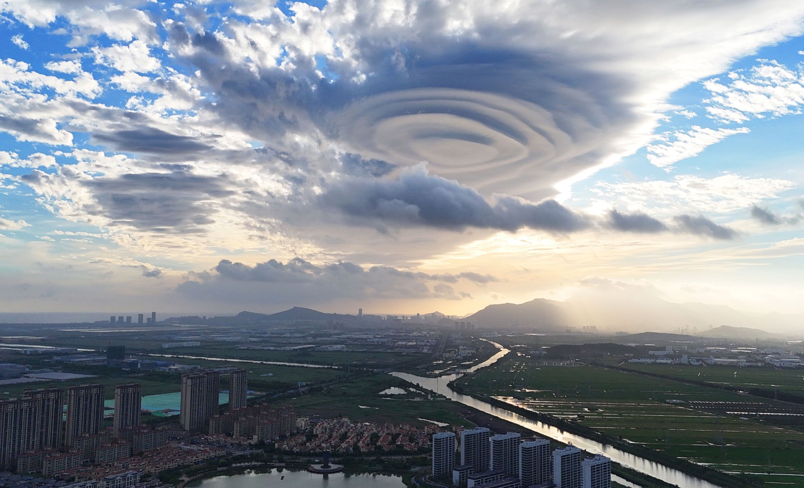 An unusual cloud formation in the sky above a city, looking like stacked discs.