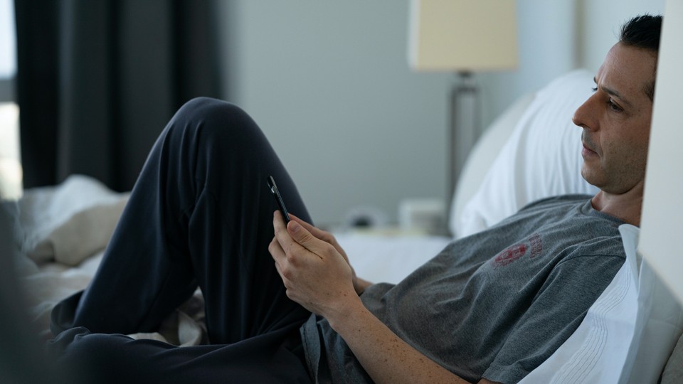 Kendall Roy, a character on HBO's 'Succession,' sits in bed with his phone in hand