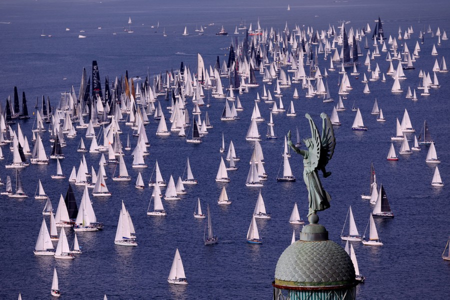 Many dozens of sailboats cluster together during a regatta.