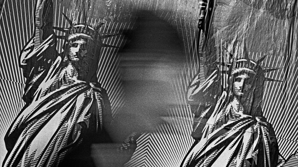 A black and white photograph of a shadow of a person walking in front of a billboard in Chinatown, depicting two linocuts of the Statue of Liberty, side by side.