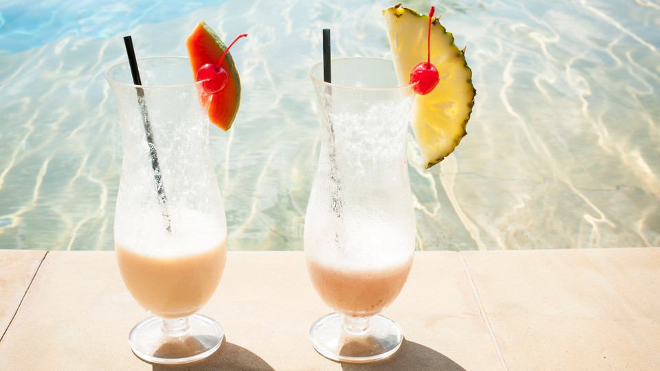 Photograph of two tropical drinks by the pool