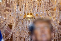 Photo of chandelier behind blurred face of Donald Trump