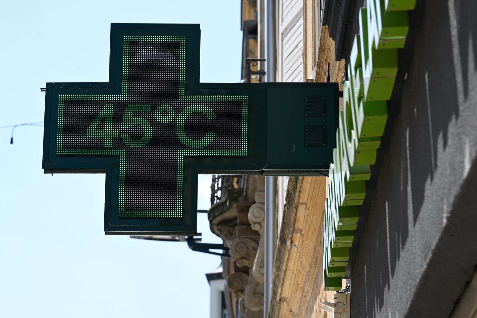 A pharmacy sign displays a temperature of 45 degrees Celsius.