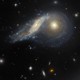 A telescopic view of two colliding spiral galaxies, with one tilted and slightly warped