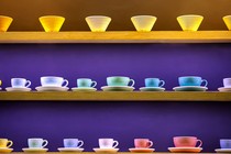 Rows of colorful coffee cups and glasses on shelves