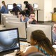 A row of people sitting at computers in a library