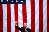 Roy Moore at a campaign rally with a giant American flag behind him