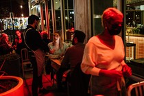 A waiter and d​iners at a restaurant in Austi​n, Texas, in January 2022