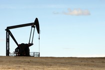 A crane-like machine drills into a field for oil