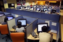 Office workers sit at cubicles in a call center